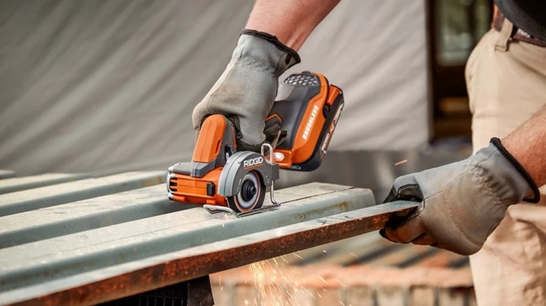 A person using a Ridgid saw on metal.