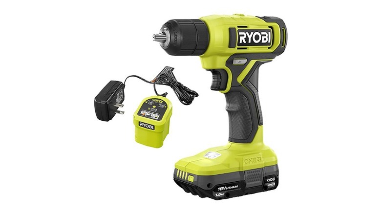 A green and black Ryobi drill with charger and battery
