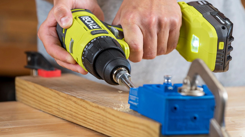 person using ryobi drill