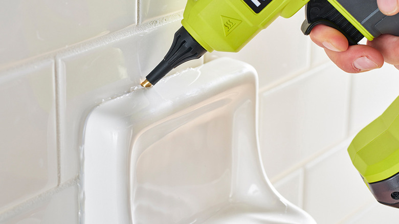 person using ryobi glue gun