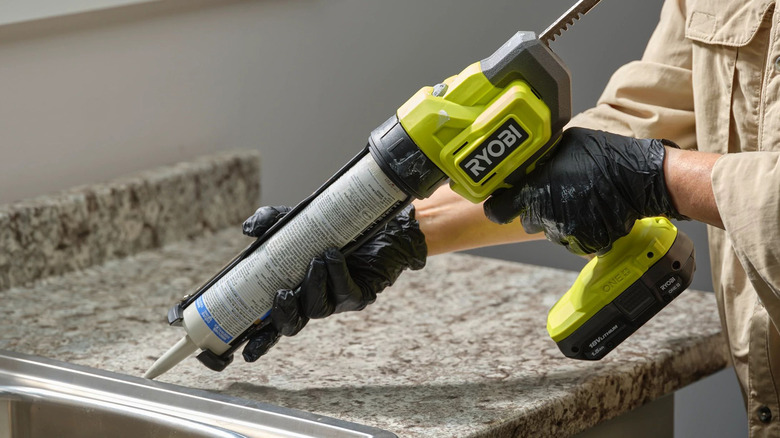 person using a ryobi caulk gun