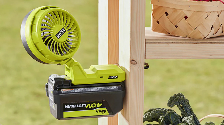 A Ryobi 40V fan battery topper clipped to a shelf.