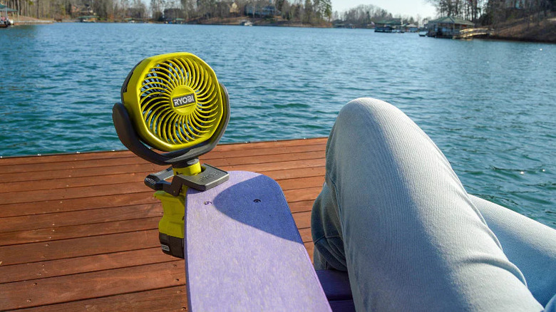 The Ryobi One+ Clamp Fan attached to a chair on a lake's dock