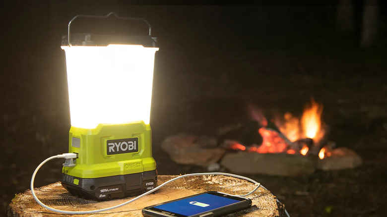 The Ryobi Area Light charging a phone at night, outside