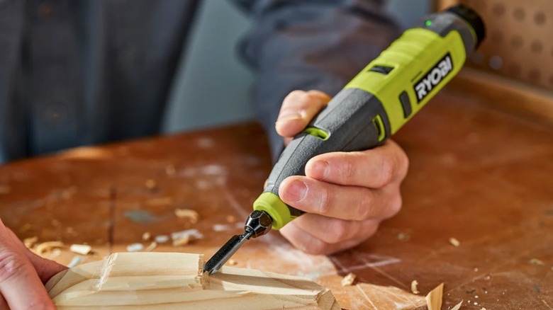 Person working with wood with a Ryobi carver