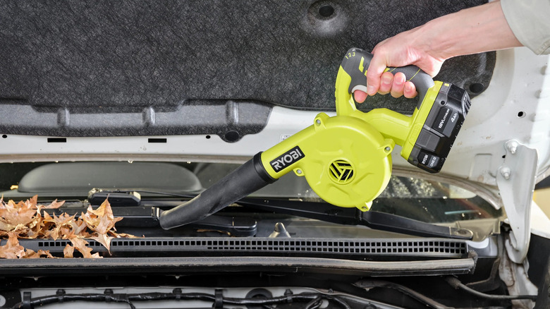A person using Ryobi cordless blower inside car