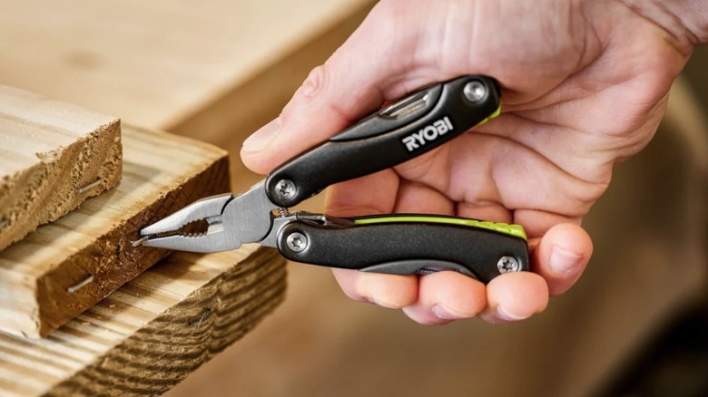 Person using pliers on a Ryobi mulit-tool