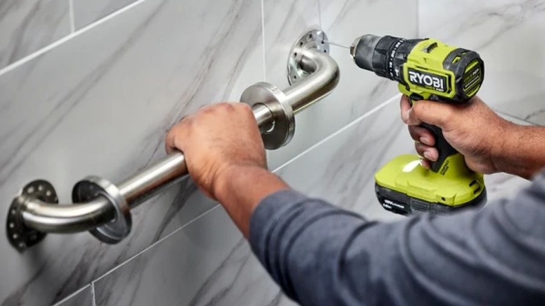 Ryobi Hammer Drill being used to secure a towel hangar in a bathroom.