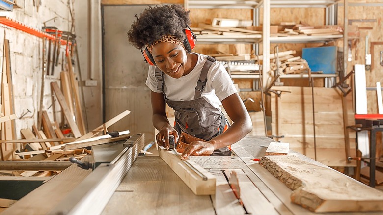 Person smiling while doing carpentry