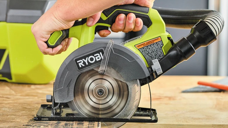 A person using a Ryobi circular saw.