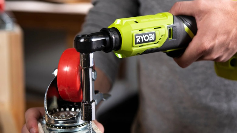A person using a Ryobi cordless ratchet.