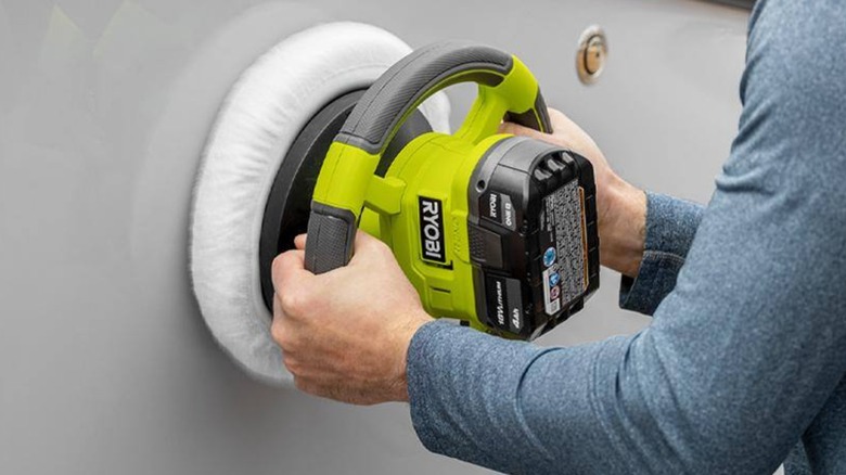 A person using a Ryobi buffer on metal.