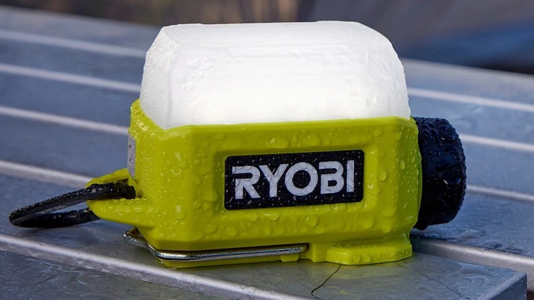 The Ryobi USB Lithium Cordless Compact Area Light on a table in a rainstorm.