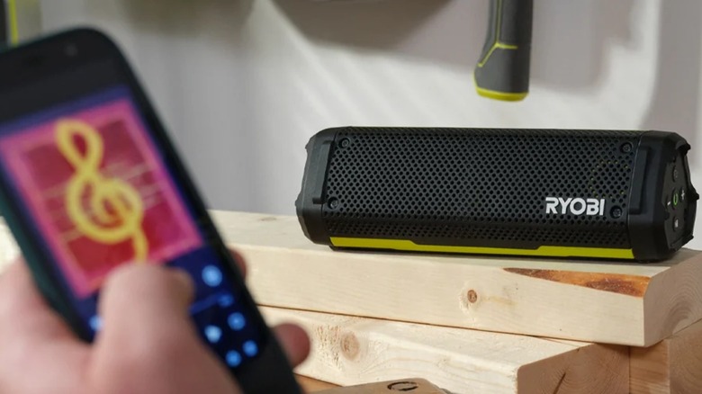 A person streaming music to the Ryobi USB Lithium Cordless Bluetooth Charging Speaker.