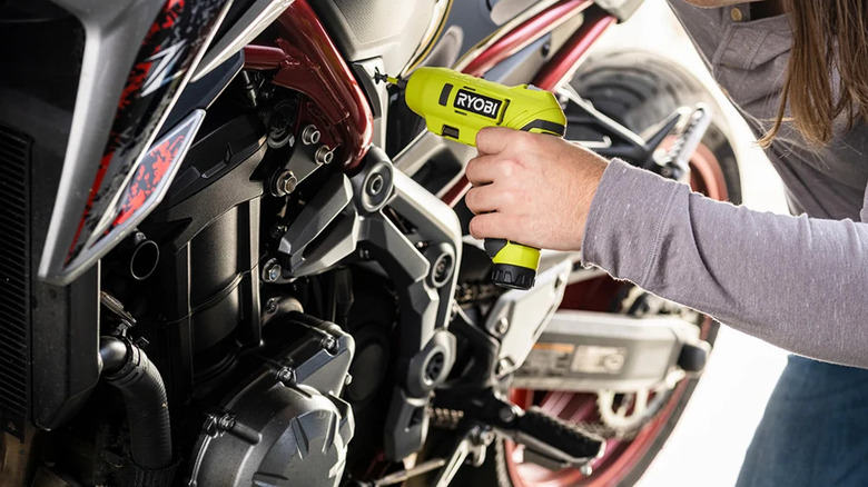 A person using Ryobi screwdriver on a bike