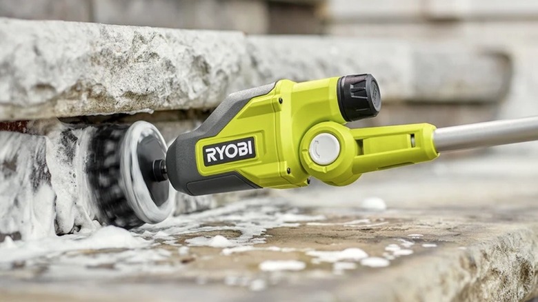 Person using Ryobi USB Lithium power scrubber to clean stone steps