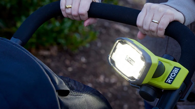 Person pushing a stroller with a Ryobi USB Lithium clamp light on the handle