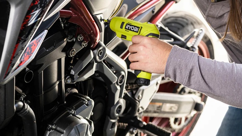 Person using a Ryobi USB Lithium screwdriver on a motorcycle