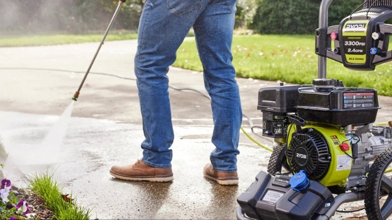 Person washing driveway using the 3300 PSI 2.4 GPM Cold Water Gas Pressure Washer