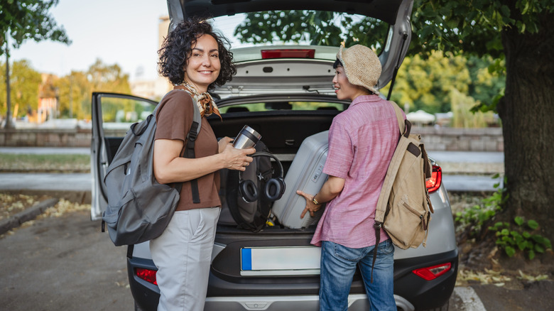 road trippers unloading their car's trunk
