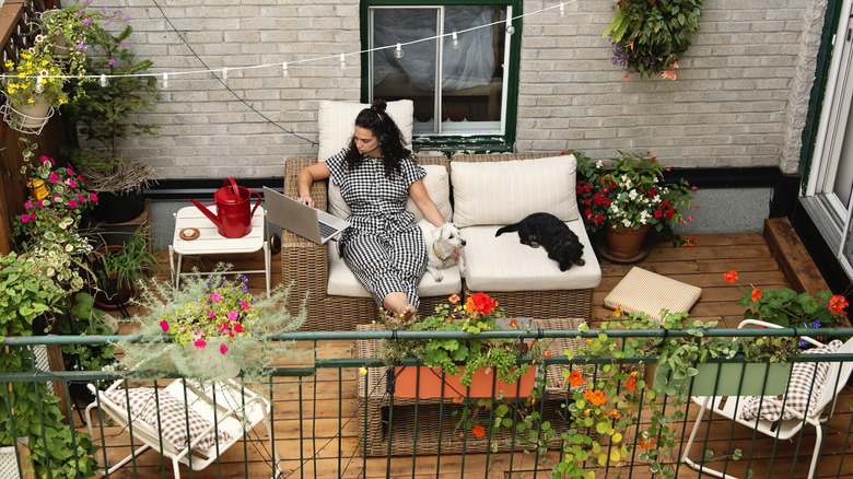 Someone working on a laptop on a well-decorated deck.