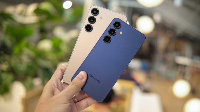 Person holding up two Samsung Galaxy smartphones