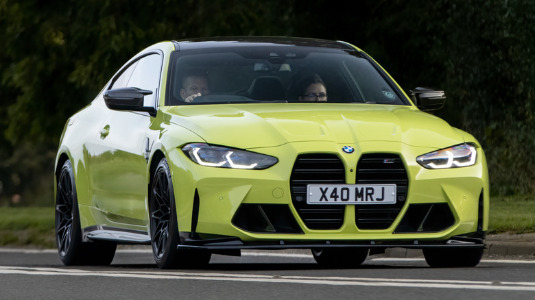 A bright yellow BMW M4 being driven.