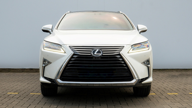 A front-end view of a white Lexus RX with its spindle grille design.