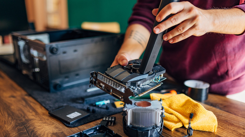 gamer cleaning up a graphics card with vaccum