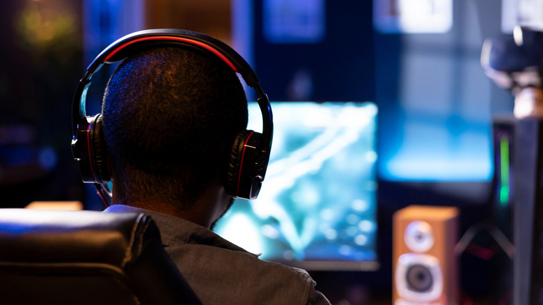 shot of gamer from behind playing on computer