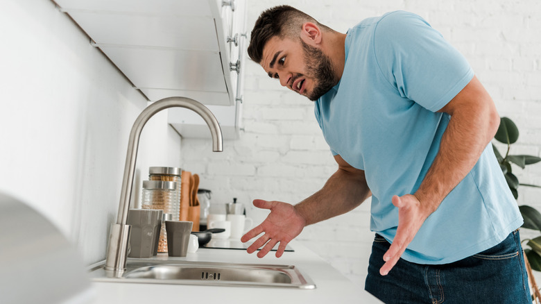 Person looking confused while checking out their kitchen sink