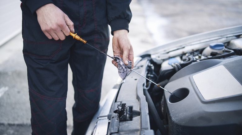 Person checking the oil levels in their car