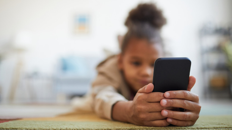 A kid holding a phone and browsing