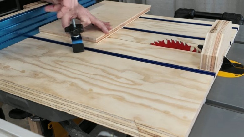 Person clamping board to miter sled