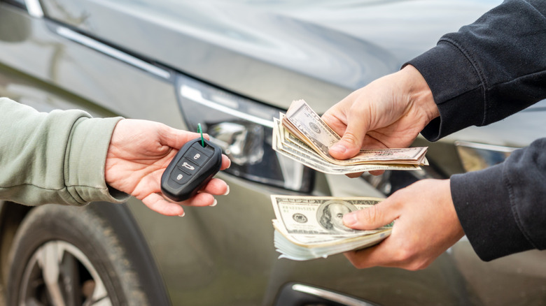 Two people exchanging cash for car keys