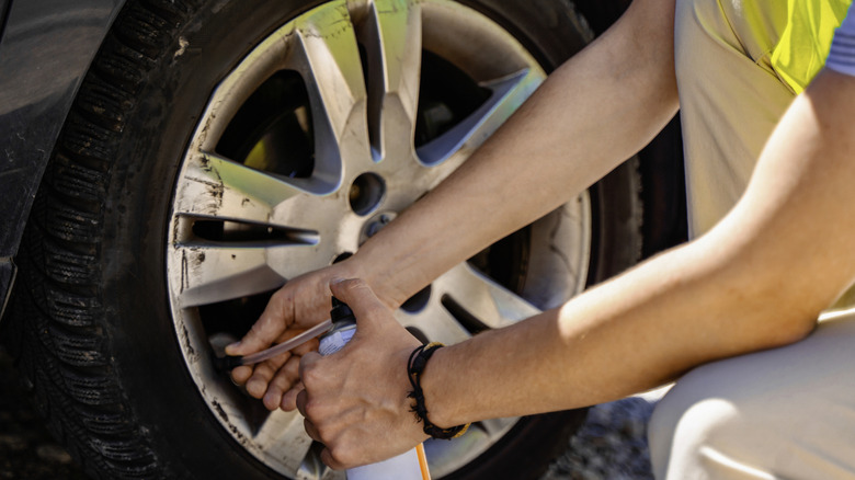 Person pumping tire sealant into their tire