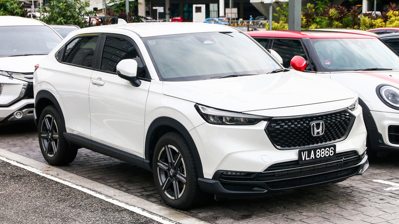A white Honda HR-V parked outside on a parking lot.