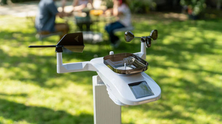 The AcuRite Weather Station in a yard with a family in the background