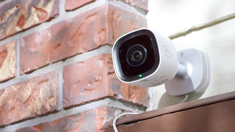 Outdoor camera overtop of a door outside a brick house