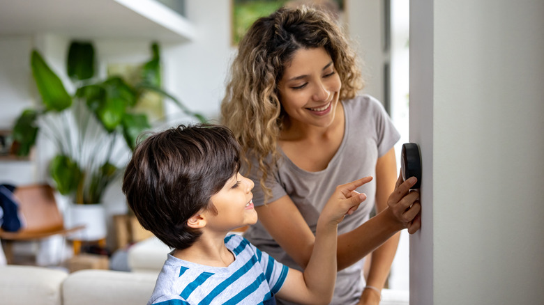 Mother and son at smart home control panel