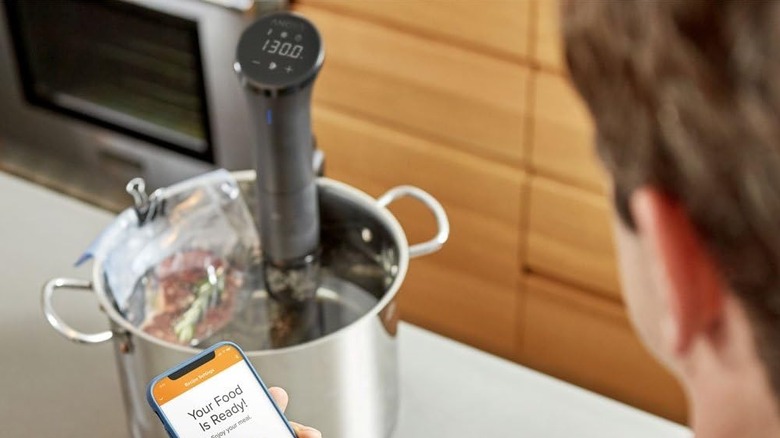 person using anova sous vide machine