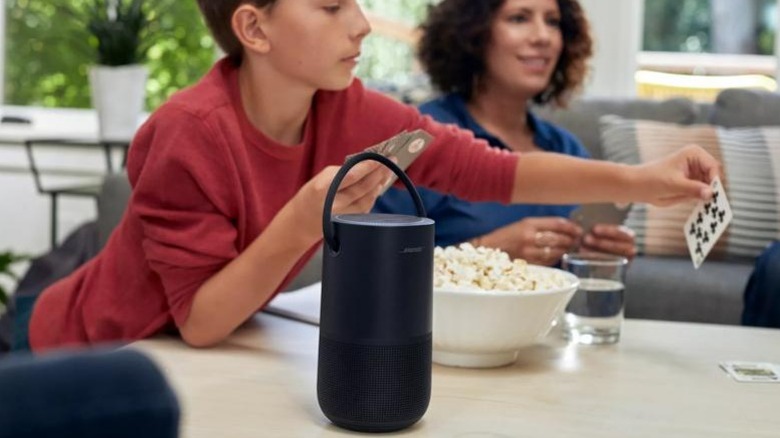 Bose Portable Smart Speaker on table while family plays cards