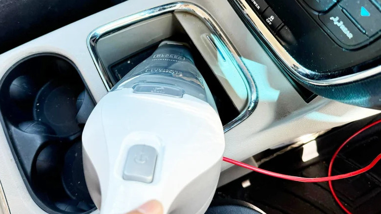 SlashGear reviewer using the Black + Decker Dustbuster QuickClean in their car