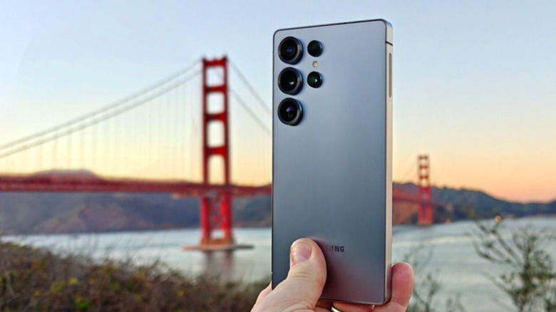 Hand holding Samsung Galaxy S25 Ultra in front of Golden Gate Bridge