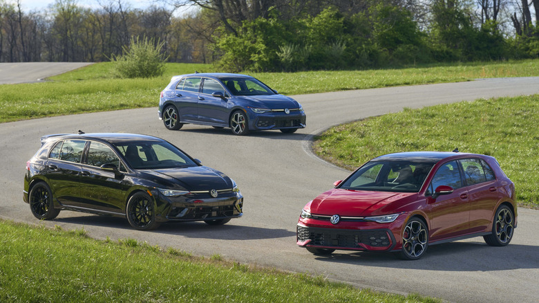 2025 Volkswagen Golf R and GTI group parked on race track.
