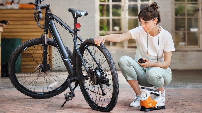A person using Stihl inflator on a bike tire