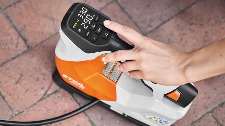 Person pressing buttons on a Stihl Inflator