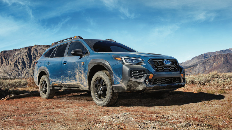 2025 Subaru Outback Wilderness, front 3/4 view, blue exterior, bodywork covered in dirt