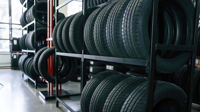 Many new tires placed on tire racks indoors.