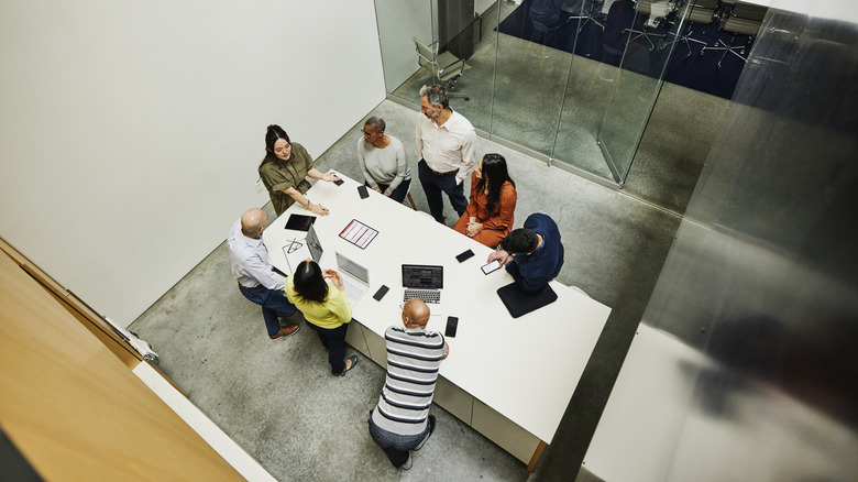 A group of people sitting at a table while working together